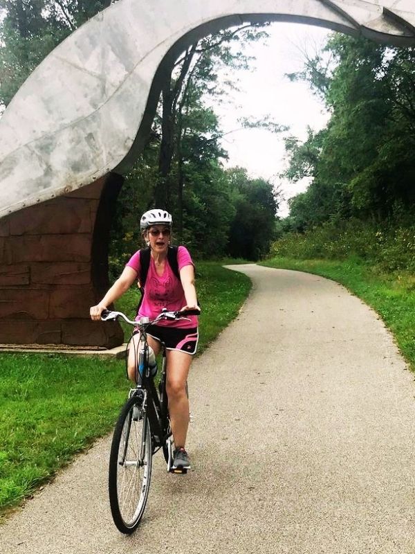 Kim riding a bike along Trout Run Trail in Decorah