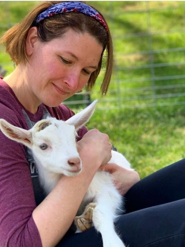 Kim with a kid during goat yoga at Honey Creek Creamery