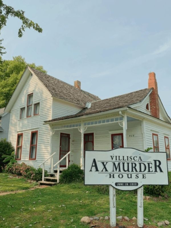 The exterior of the Villisca Axe Murder House and a sign 