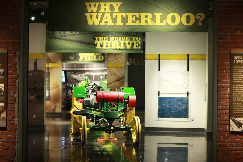 A green and yellow antique tractor inside the John Deere Tractor and Engine Museum