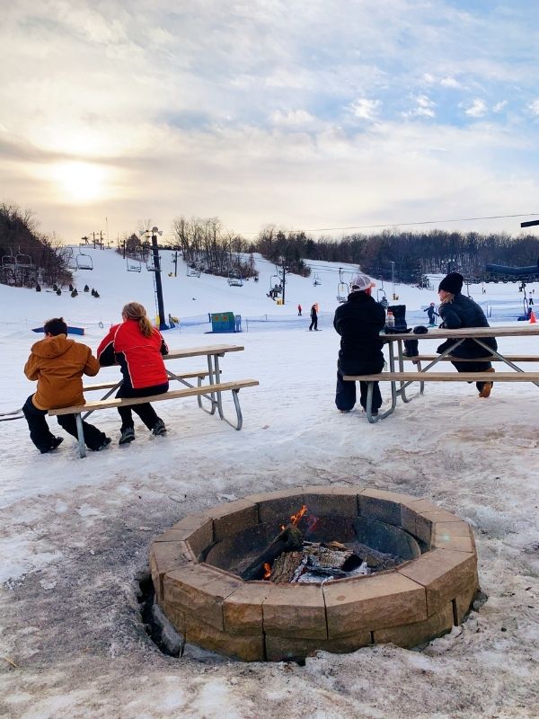 Skiers resting at on benches at Seven Oaks Recreation in Boone, Iowa