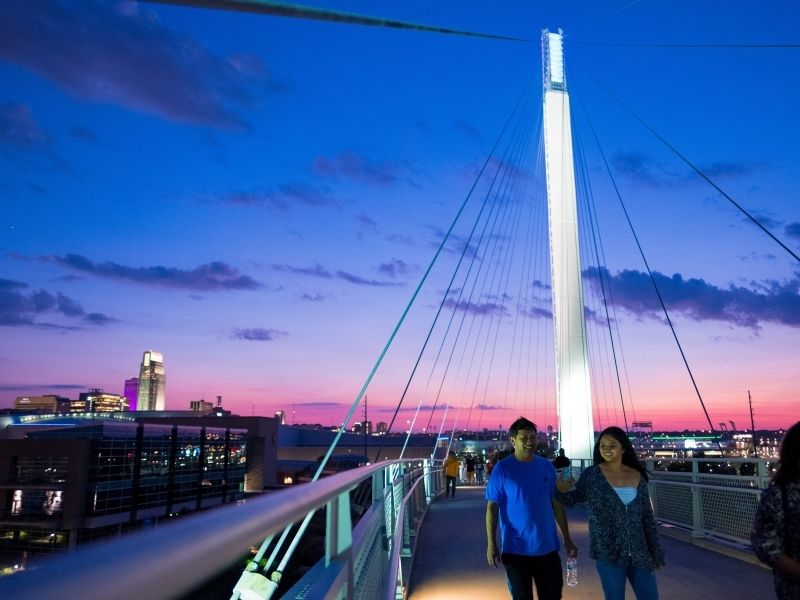 Walkers on the Bob Kerrey Pedestrian Bridge at night