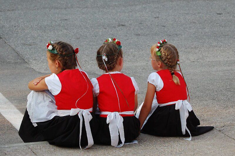 Three girls wait for the Nordic Fest  parade in Decorah