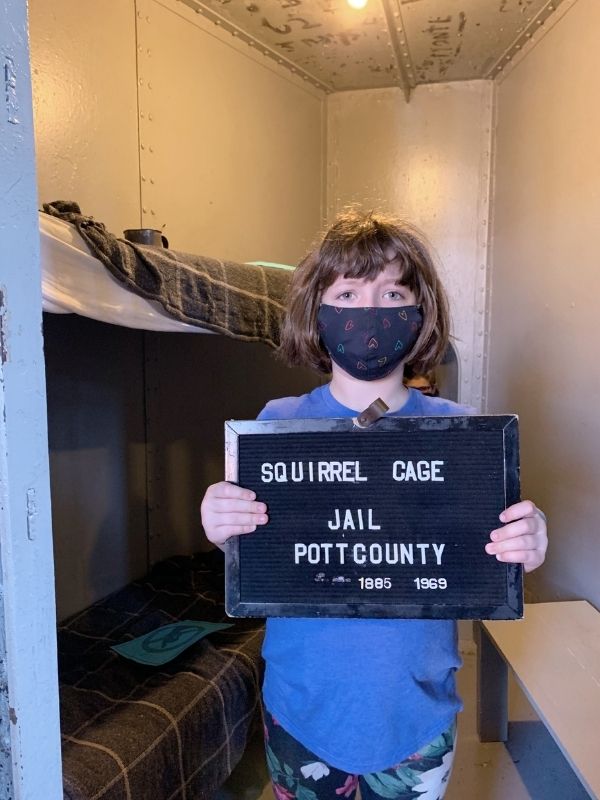 Young jailbird holding Squirrel Cage Jail sign