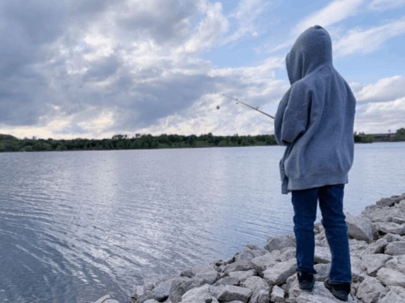 Boy fishing from the shore at Lake Icaria