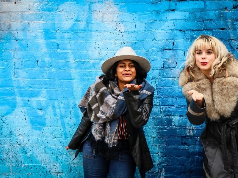 Two women pose by a mural in Dubuque