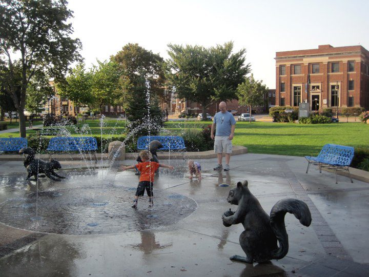 A family plays in the splash pad at Bayliss Park