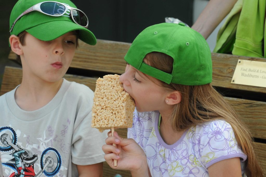 Girl eating a Rice Krispie treat on a stick