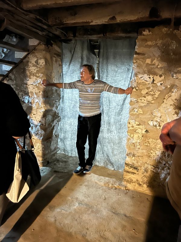 Tour guide standing in front of the entrance to the secret room in the Hitchcock House basement