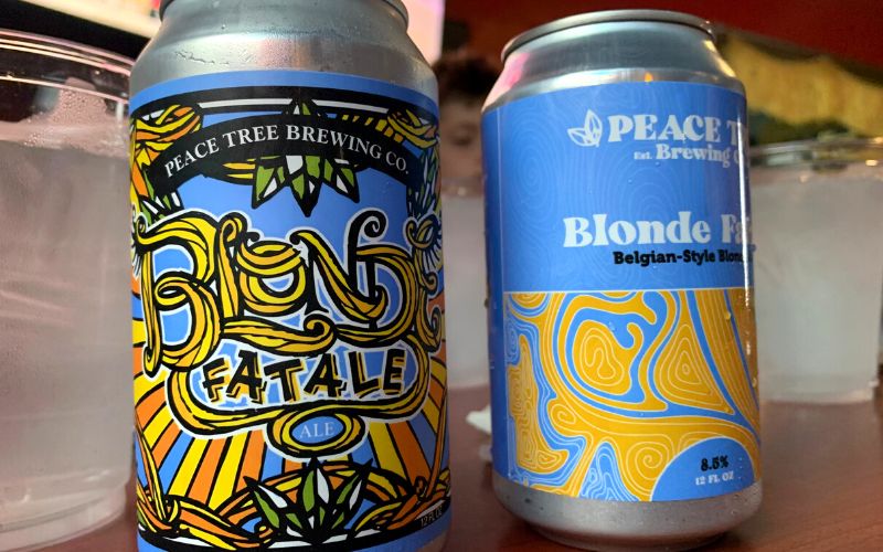 Two different cans of Blonde Fatale beer by Peace Tree Brewing Co.