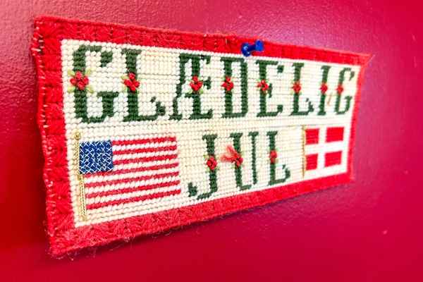 A knit sign in Danish with the American flag and Danish flag