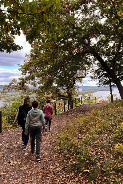Three people hiking toward an overlook at Effigy Mounds National Monument in northeastern Iowa
