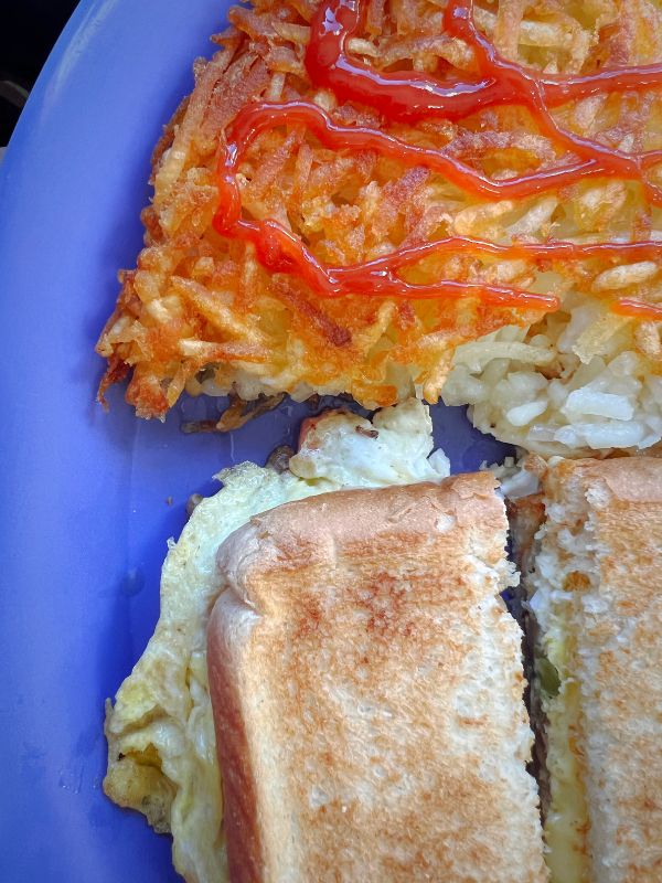 Hashbrowns, eggs and toast on a blue plate at Jet's Meats and Cafe in Waukon