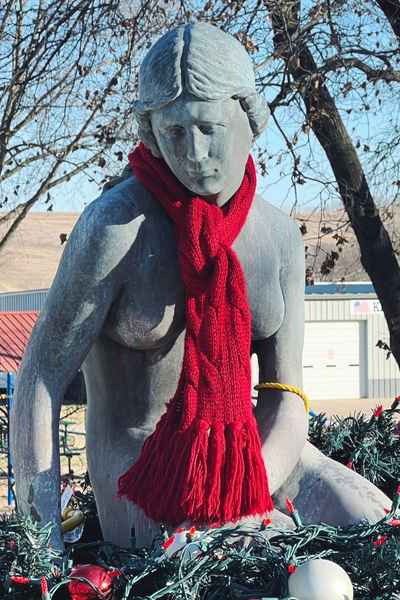 A red scarf and holiday lights surround the Little Mermaid replica in Kimballton, Iowa