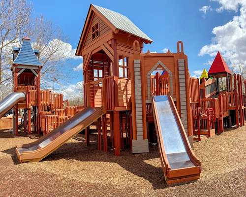 Dream Playground is a wooden playground with colorful rooftops and silver slides