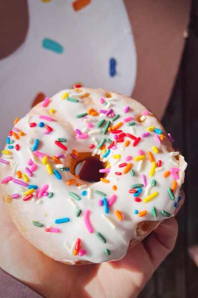 A white frosted donut with colorful sprinkles from South Shore Donut Co. in Clear Lake