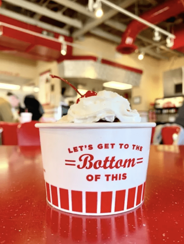 A frozen custard sundae in a red and white cup at Freddy's Frozen Custard and Steakburgers