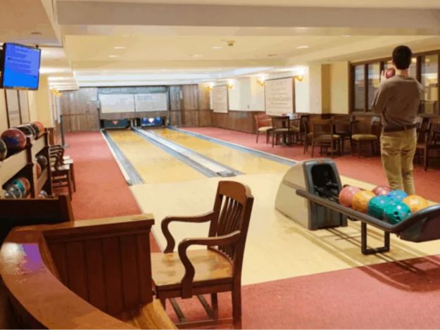 A boy bowls at the two-lane bowling alley at Hotel Pattee
