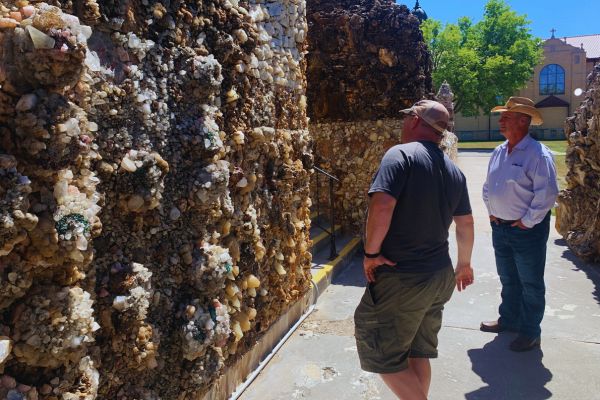 Two men look at a wall at the grotto in Iowa