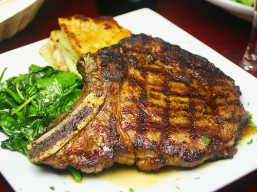 Large steak served over greens and potatoes 
