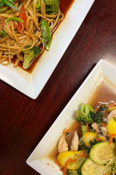 Two dishes with colorful veggies at Asian Pho Bistro