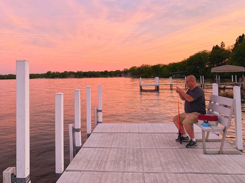 A man preps a fishing pole on a dock near Crescent Beach Family Resort in Okoboji 