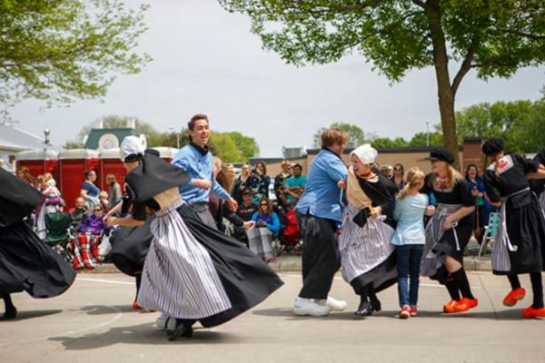 Dancers dressed in traditional Dutch costumes dance in the street in Orange City